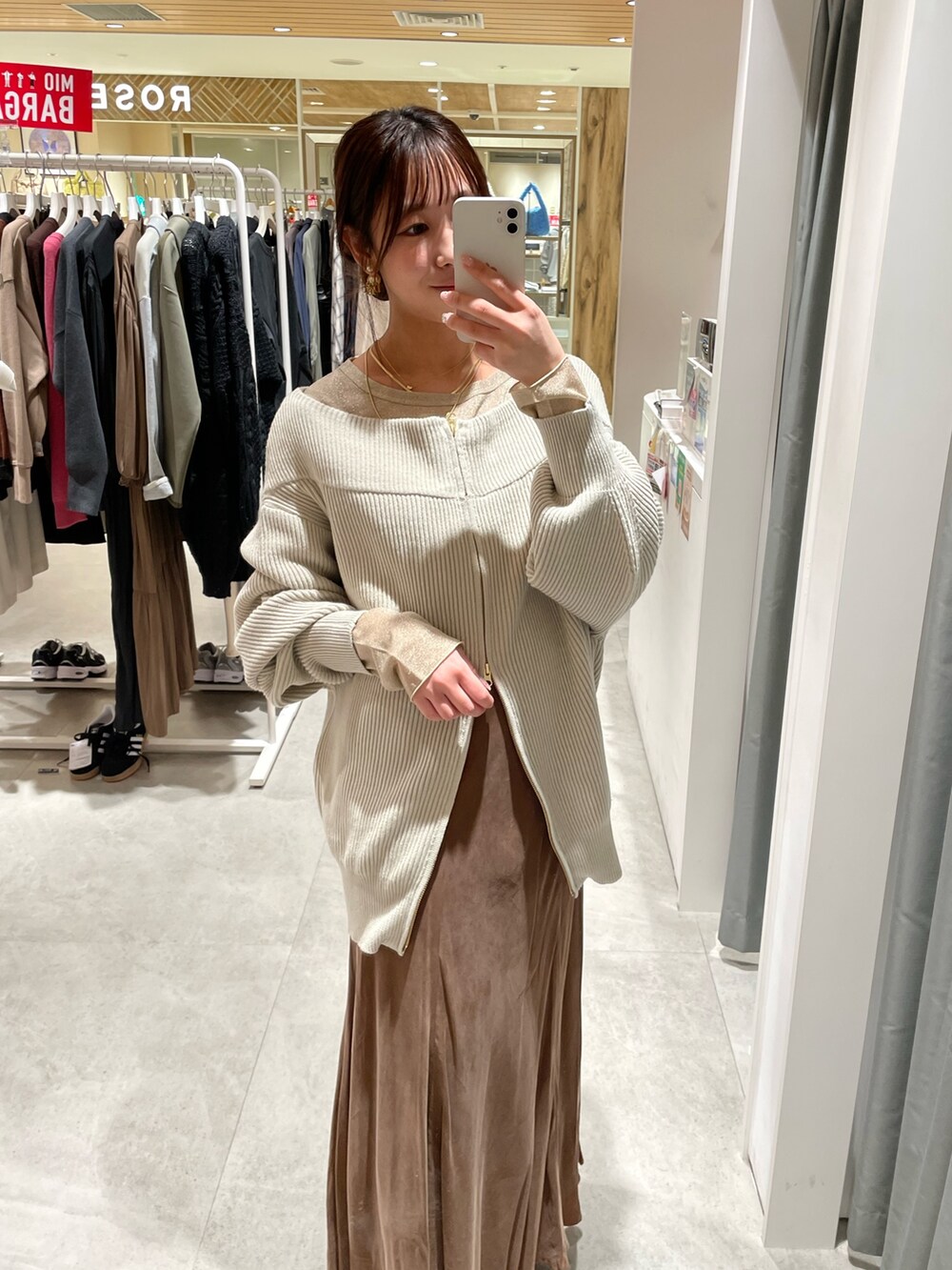 グレー系のニット/セーター、ブラウン系のスカート、ゴールド系のTシャツ/カットソーを着用したレディースの冬コーディネートの3枚目の写真