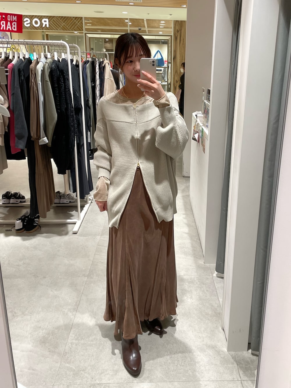 グレー系のニット/セーター、ブラウン系のスカート、ゴールド系のTシャツ/カットソーを着用したレディースの冬コーディネートの4枚目の写真