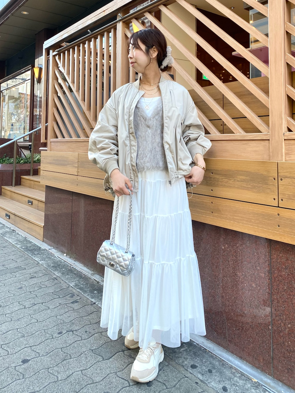 ベージュ系のベスト、ベージュ系のMA-1、ホワイト系のスカートを着用したレディースの秋コーディネートの2枚目の写真