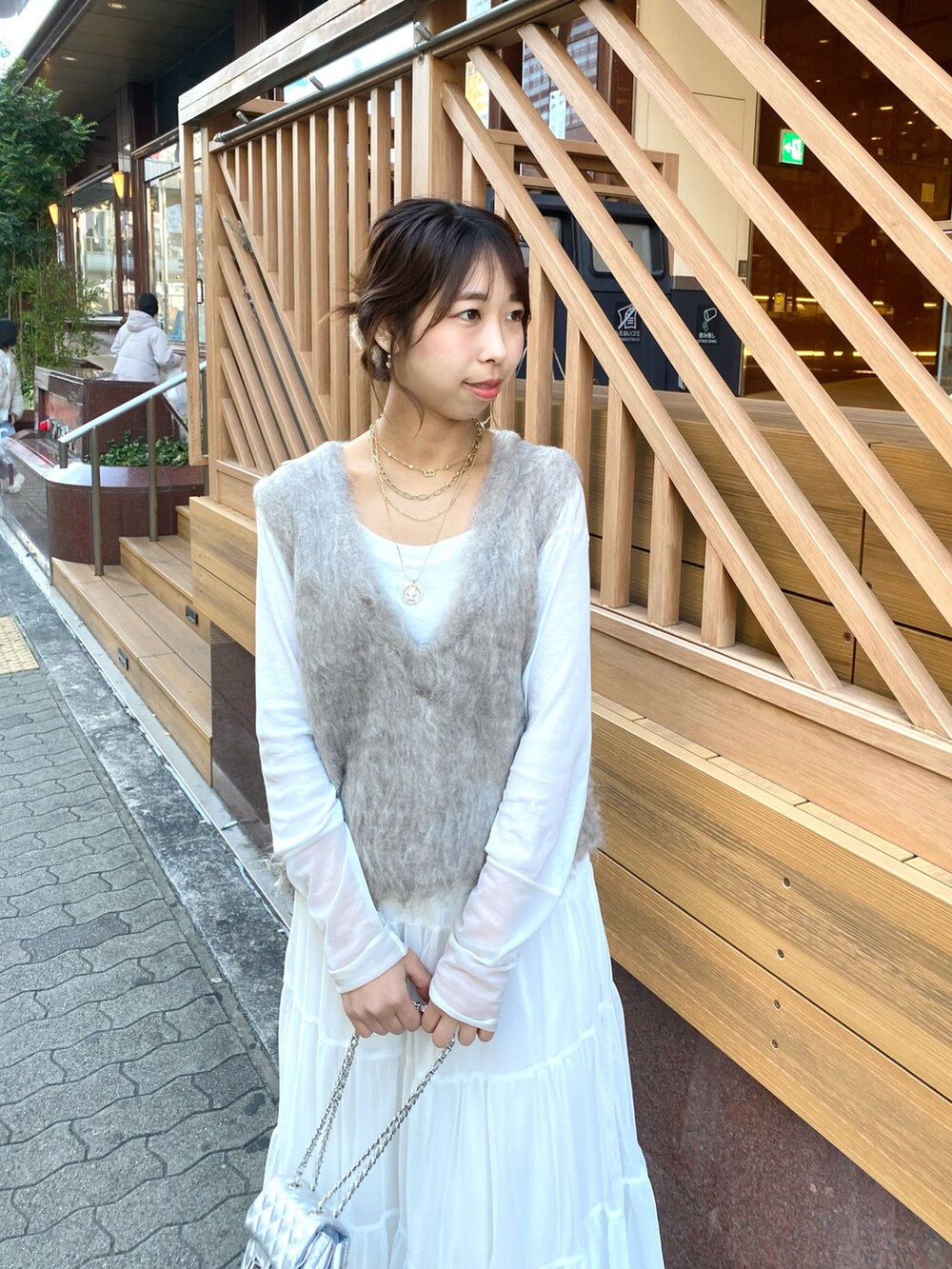 ベージュ系のベスト、ベージュ系のMA-1、ホワイト系のスカートを着用したレディースの秋コーディネートの5枚目の写真