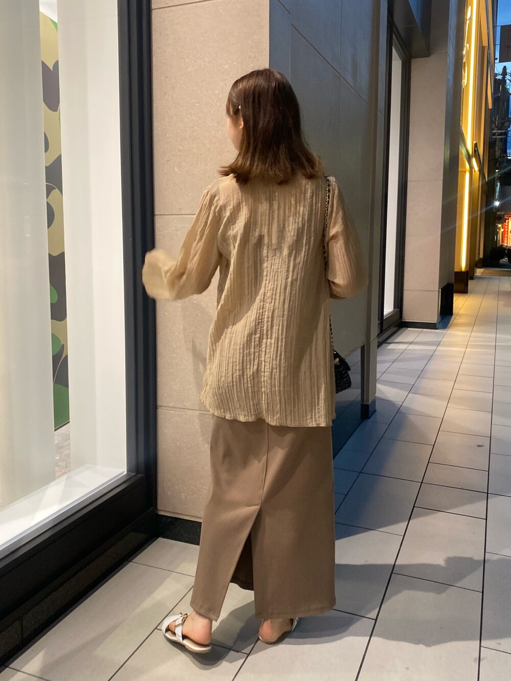 ベージュ系のワンピース、ブラック系のトートバッグを着用したレディースの夏コーディネートの2枚目の写真