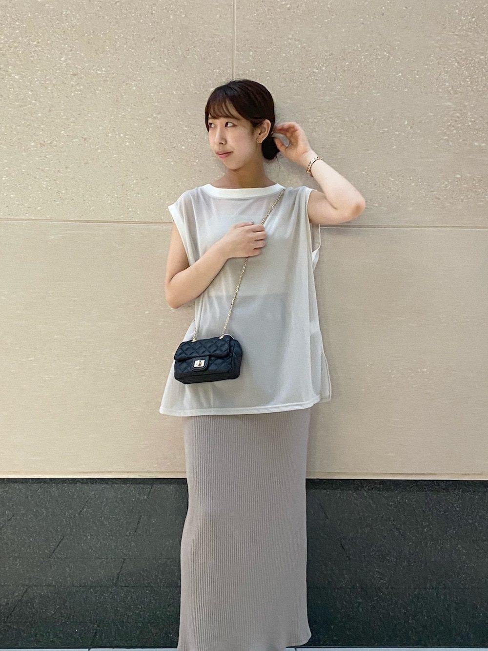 ブラック系のショルダーバッグ、グレー系のワンピース、ブラック系のサンダルを着用したレディースの夏コーディネートの3枚目の写真