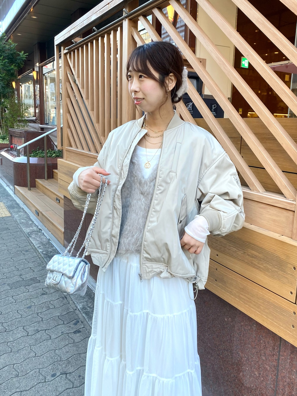 ベージュ系のベスト、ベージュ系のMA-1、ホワイト系のスカートを着用したレディースの秋コーディネートの4枚目の写真