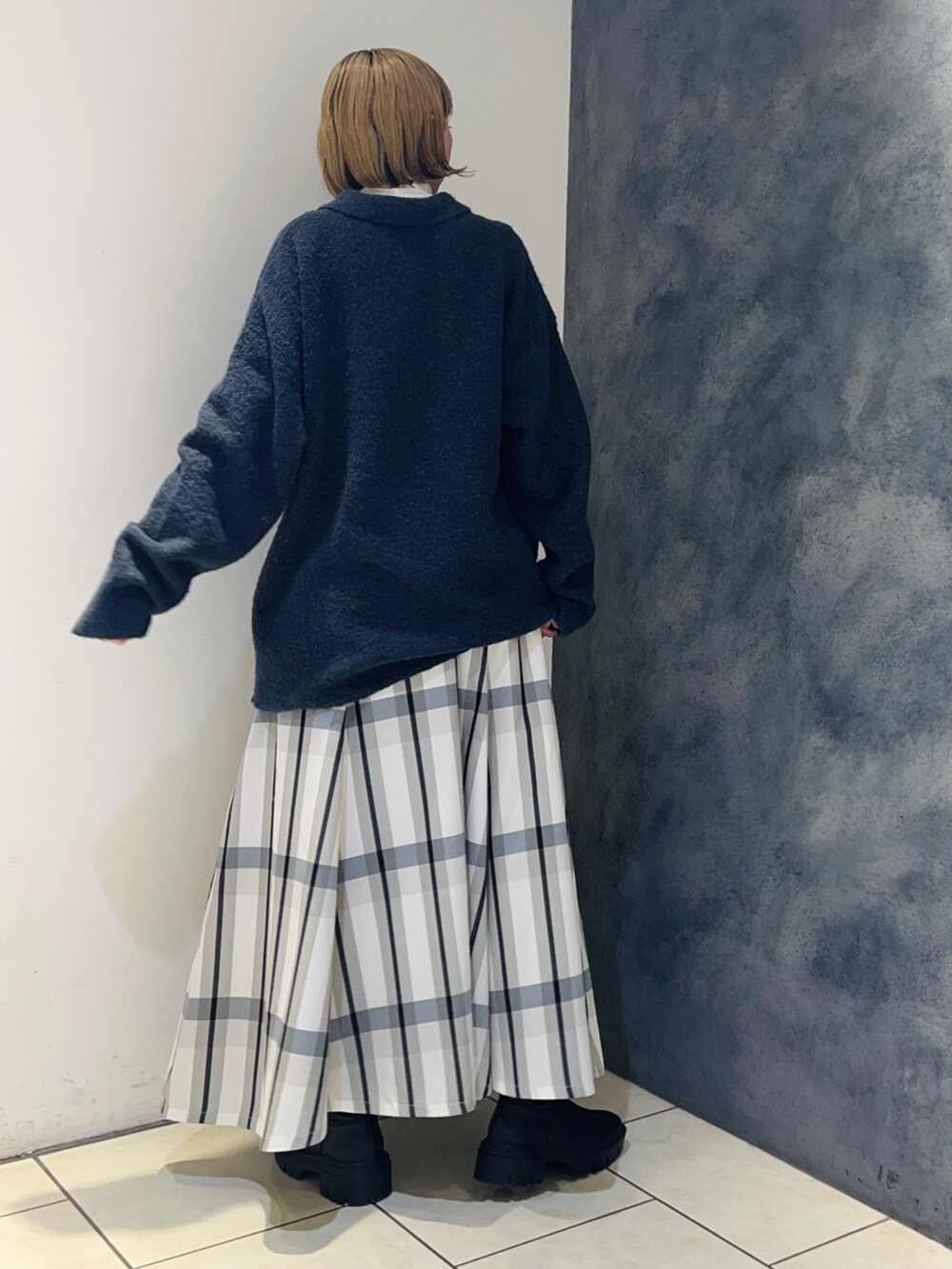 ブルー系のニット/セーター、ホワイト系のスカート、ホワイト系のTシャツ/カットソーを着用したレディースの冬コーディネートの4枚目の写真