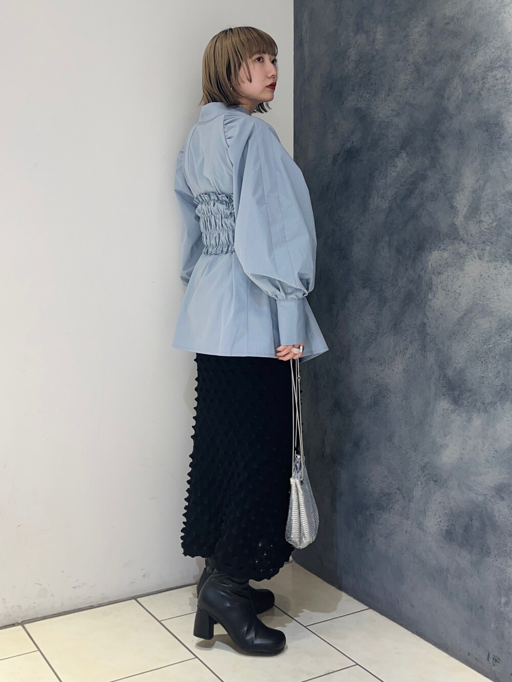 ブルー系のシャツ/ブラウス、ブラック系のスカート、ブラック系のブーツを着用したレディースの冬コーディネートの3枚目の写真