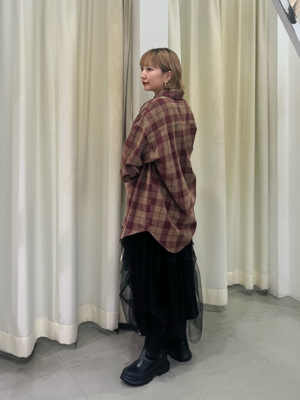 ブラウン系のシャツ/ブラウス、ブラック系のスカート、ブラック系のブーツを着用したレディースの秋コーディネートの3枚目の写真