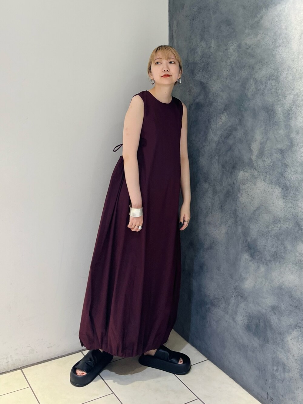 レッド系のワンピース、ブラック系のサンダル、ホワイト系のネックレスを着用したレディースの夏コーディネートの4枚目の写真