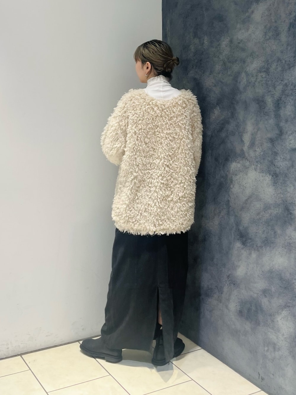 ブラック系のスカート、ホワイト系のカーディガン/ボレロ、ホワイト系のTシャツ/カットソーを着用したレディースの冬コーディネートの3枚目の写真