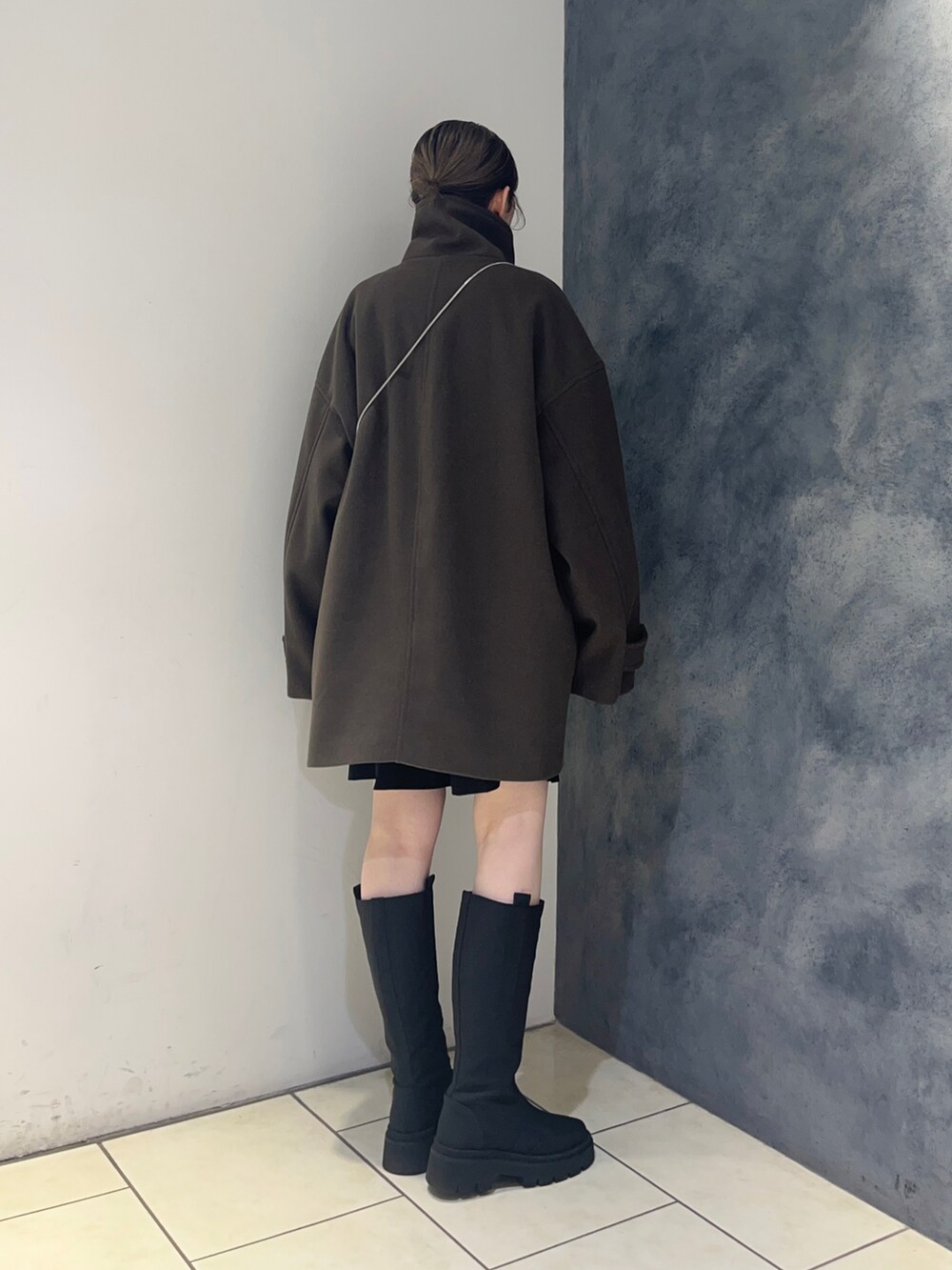 ブラウン系のその他アウター、ブラック系のブーツ、シルバー系のショルダーバッグを着用したレディースの秋コーディネートの4枚目の写真