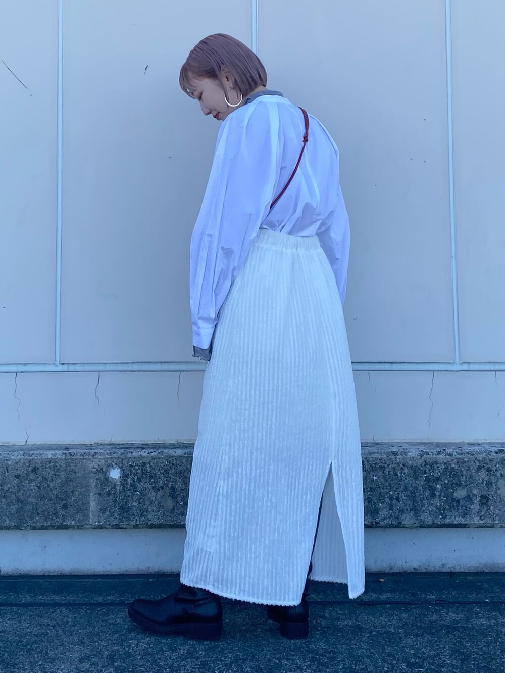 レッド系のショルダーバッグ、ホワイト系のシャツ/ブラウス、グレー系のTシャツ/カットソーを着用したレディースの冬コーディネートの3枚目の写真
