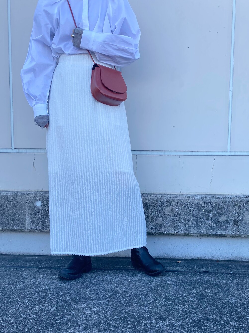 レッド系のショルダーバッグ、ホワイト系のシャツ/ブラウス、グレー系のTシャツ/カットソーを着用したレディースの冬コーディネートの4枚目の写真