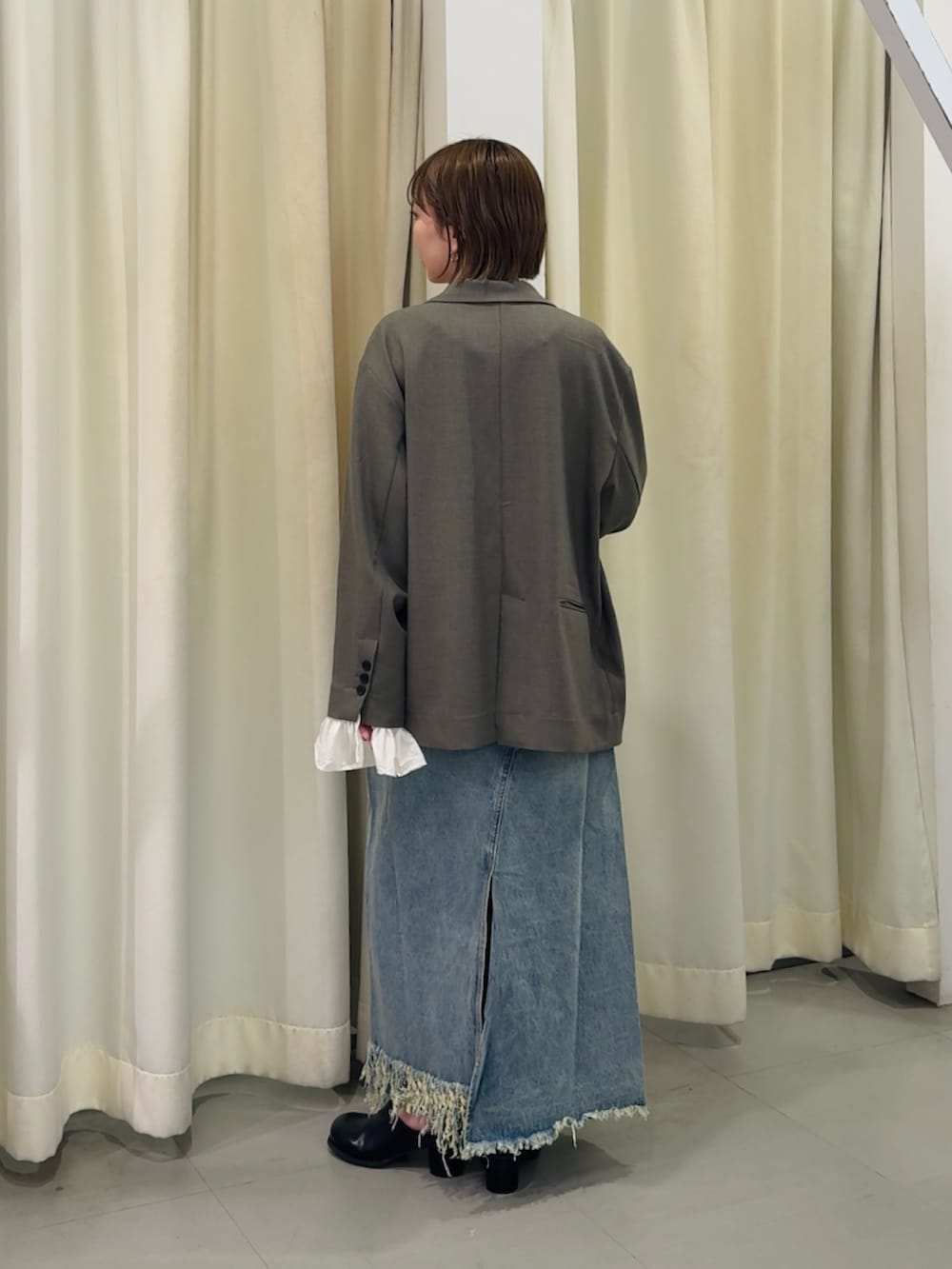 グレー系のその他アウター、ブルー系のスカートを着用したレディースの春コーディネートの2枚目の写真