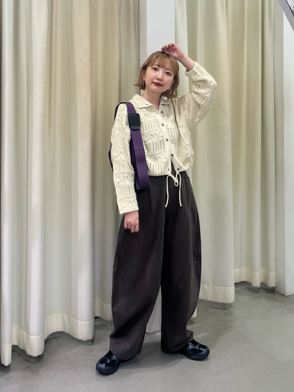 ホワイト系のカーディガン/ボレロ、グレー系のその他パンツ、パープル系のショルダーバッグを着用したレディースの秋コーディネートの4枚目の写真