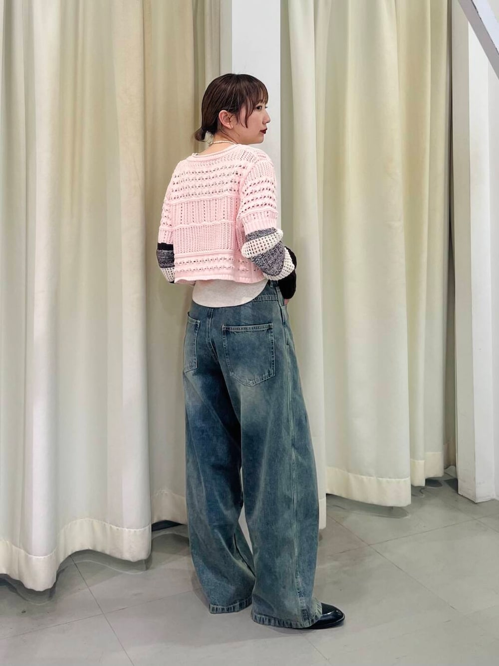 ブルー系のデニムパンツ、ベージュ系のタンクトップ、ピンク系のカーディガン/ボレロを着用したレディースの春コーディネートの2枚目の写真