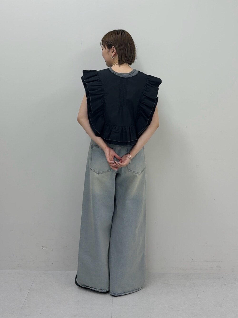 ブルー系のデニムパンツ、ブラック系のシャツ/ブラウス、グレー系のタンクトップを着用したレディースの春コーディネートの3枚目の写真