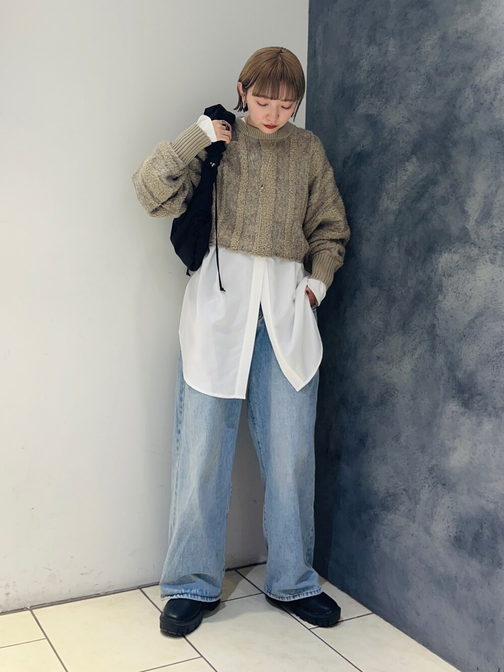 ベージュ系のニット/セーター、ホワイト系のシャツ/ブラウス、ブルー系のデニムパンツを着用したレディースの冬コーディネートの3枚目の写真