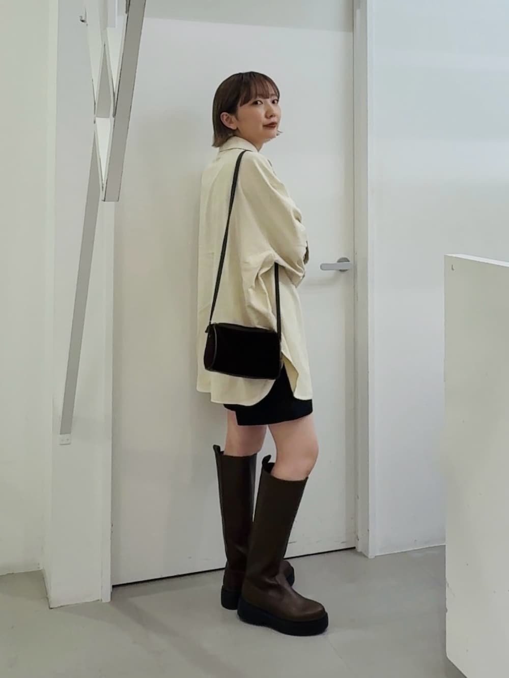 ホワイト系のシャツ/ブラウス、ブラウン系のブーツを着用したレディースの秋コーディネートの2枚目の写真