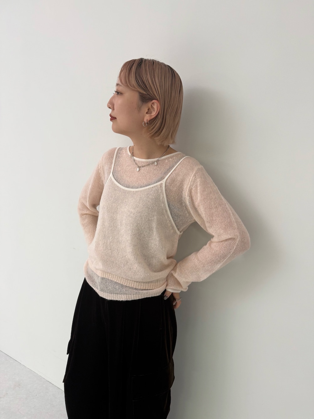 ピンク系のニット/セーター、ブラウン系のその他パンツを着用したレディースの秋コーディネートの4枚目の写真