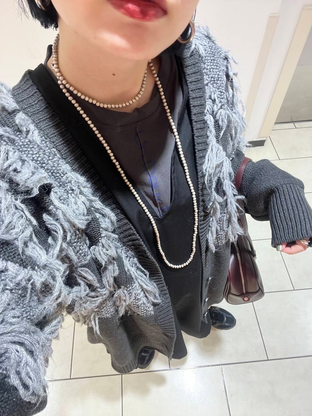 レッド系のボストンバッグ、ブラック系のワンピース、グレー系のTシャツ/カットソーを着用したレディースの秋コーディネートの5枚目の写真