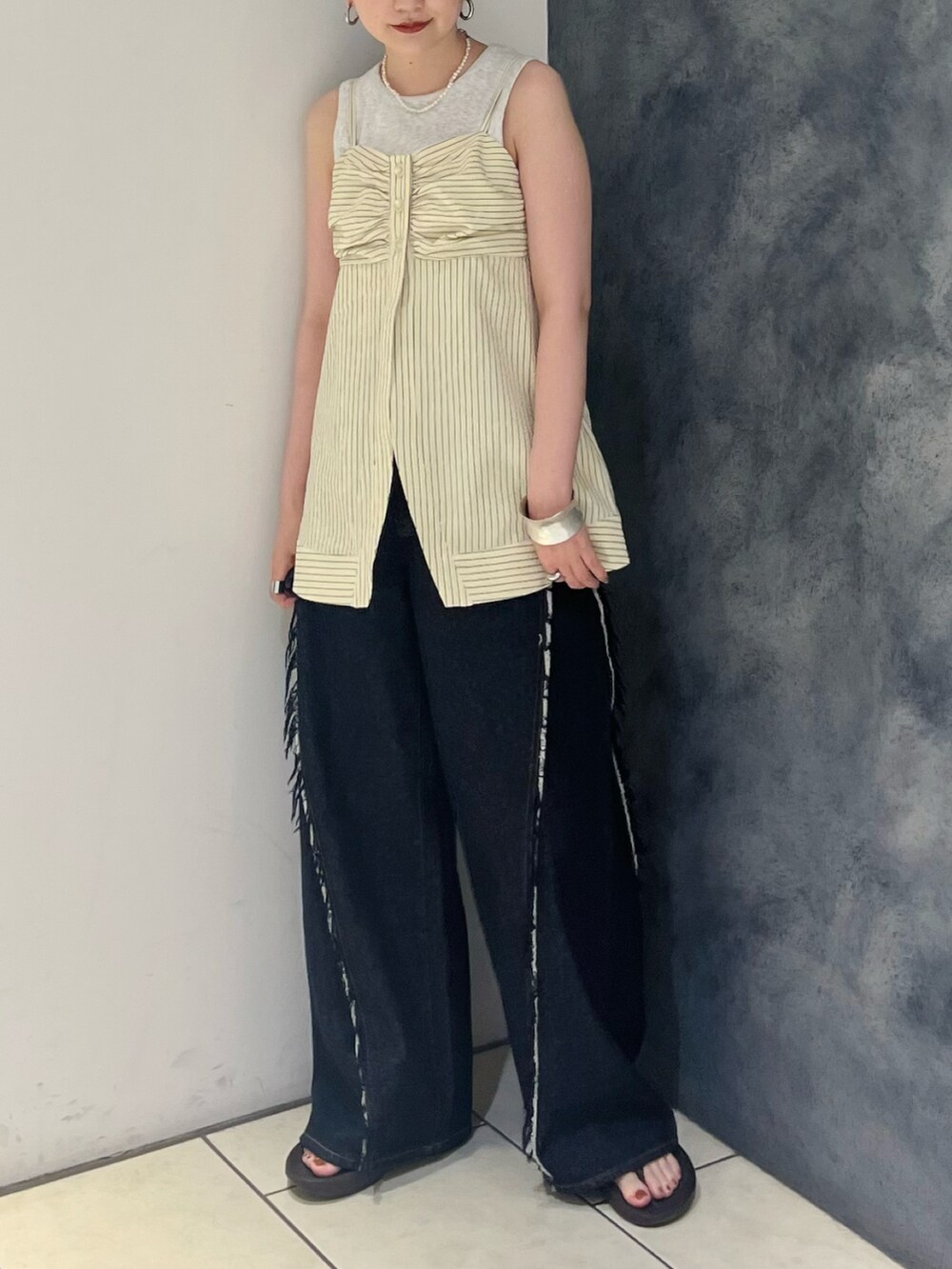 ブラック系のシャツ/ブラウス、ベージュ系のタンクトップ、ブルー系のデニムパンツを着用したレディースの夏コーディネートの2枚目の写真