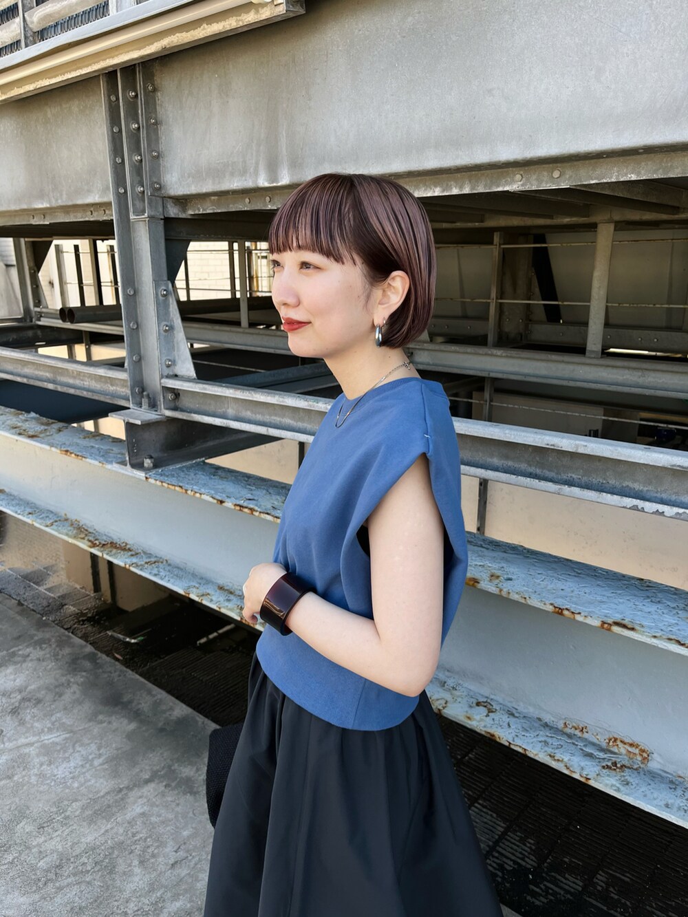 ブルー系のスウェット、グレー系のスカート、ブラック系のサンダルを着用したレディースの春コーディネートの4枚目の写真