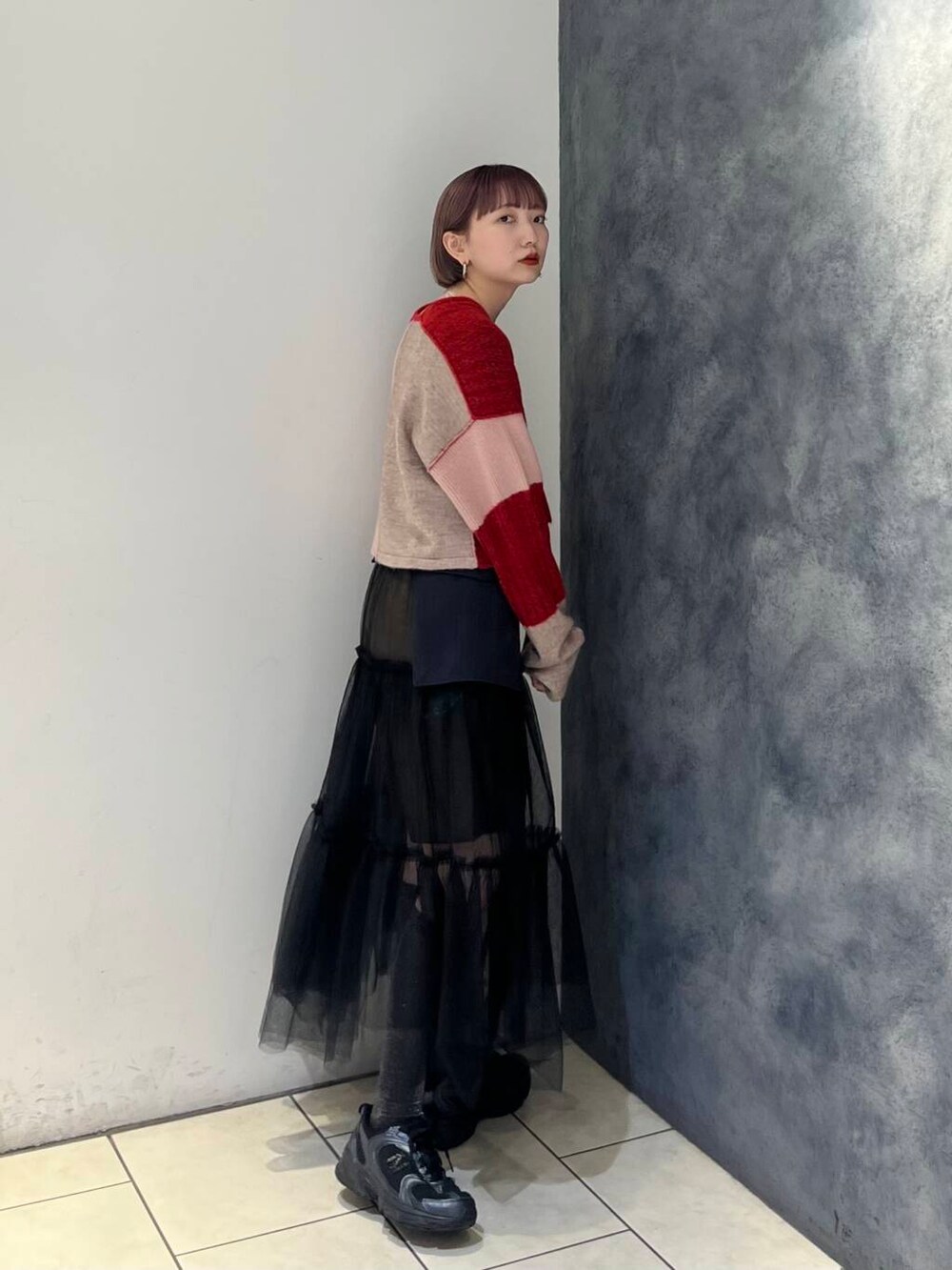 グレー系のスカート、ブラウン系のその他パンツ、レッド系のニット/セーターを着用したレディースの夏コーディネートの3枚目の写真