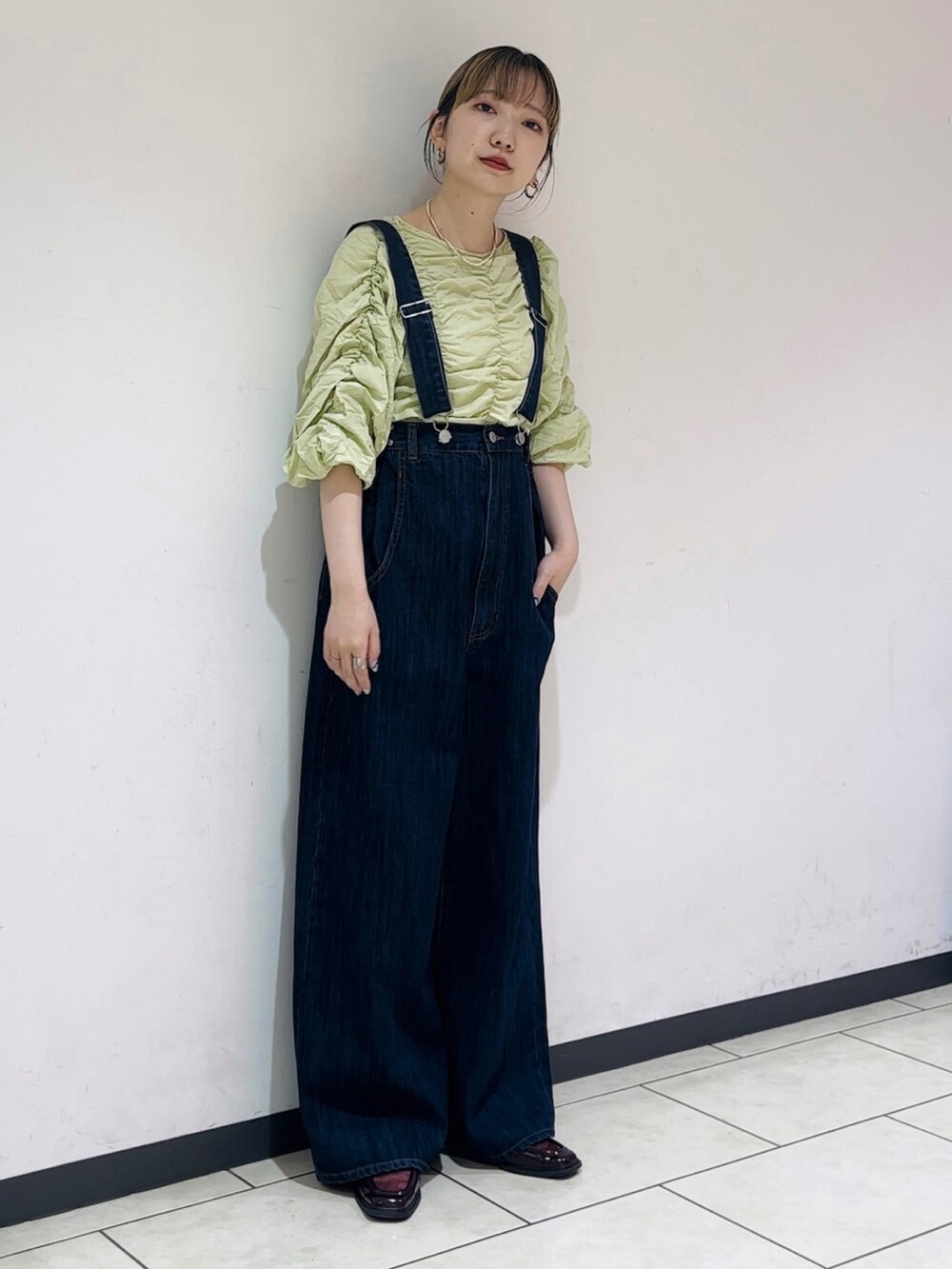 グリーン系のシャツ/ブラウス、ブルー系のサロペット/オーバーオール、レッド系のローファーを着用したレディースの春コーディネートの2枚目の写真