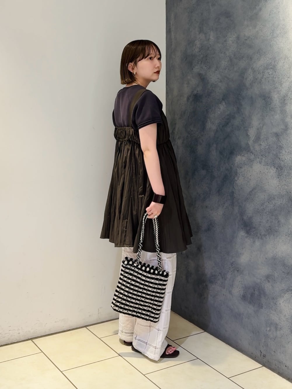 グレー系のニット/セーター、ブラウン系のワンピース、ホワイト系のその他パンツを着用したレディースの夏コーディネートの2枚目の写真