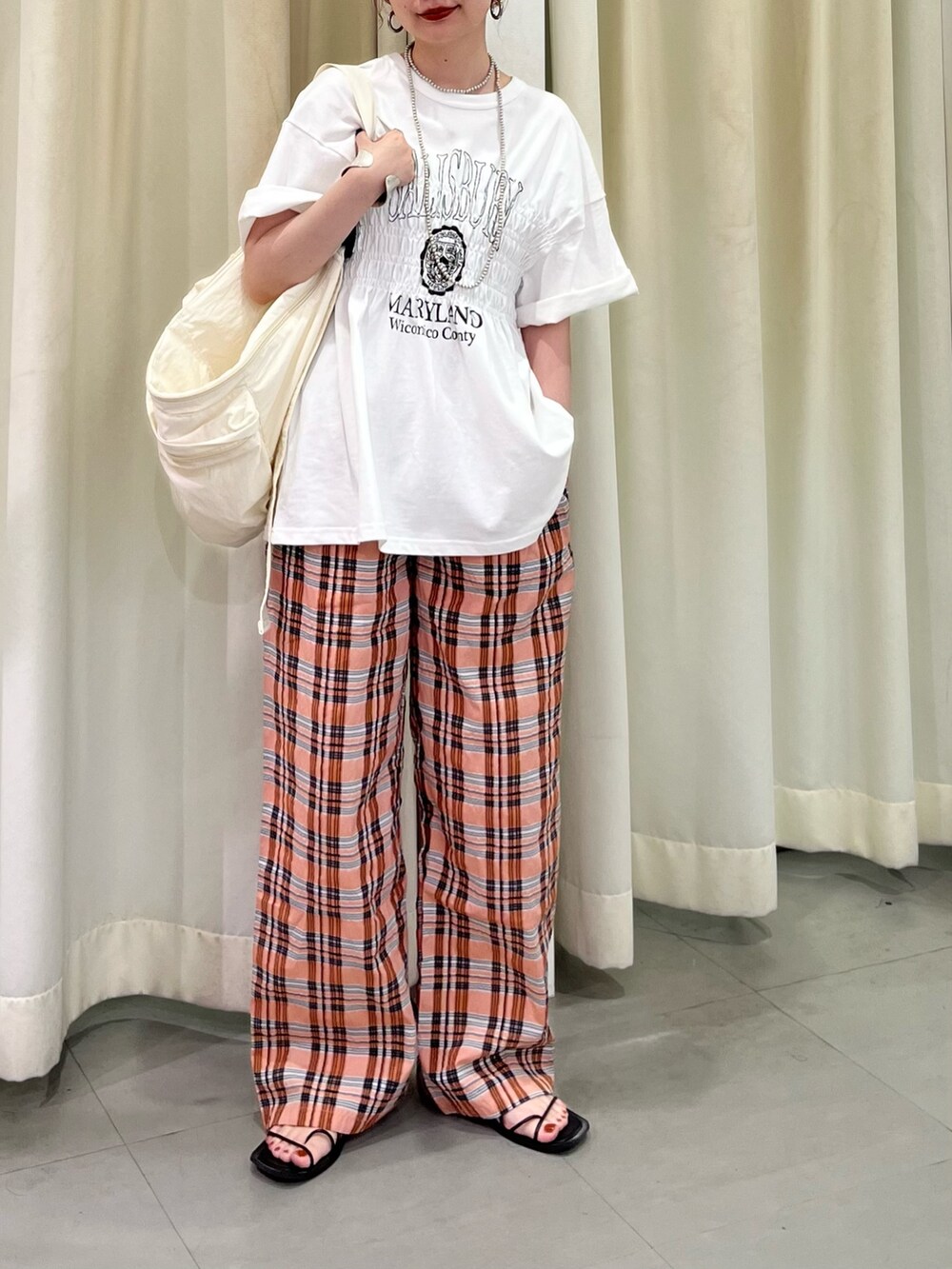 ホワイト系のTシャツ/カットソー、オレンジ系のその他パンツ、ホワイト系のショルダーバッグを着用したレディースの夏コーディネートの2枚目の写真