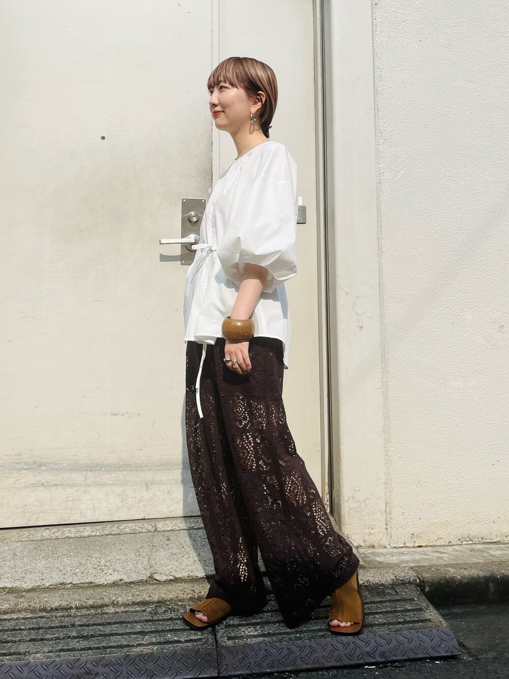 ホワイト系のシャツ/ブラウス、ブラウン系のその他パンツ、イエロー系のサンダルを着用したレディースの夏コーディネートの2枚目の写真