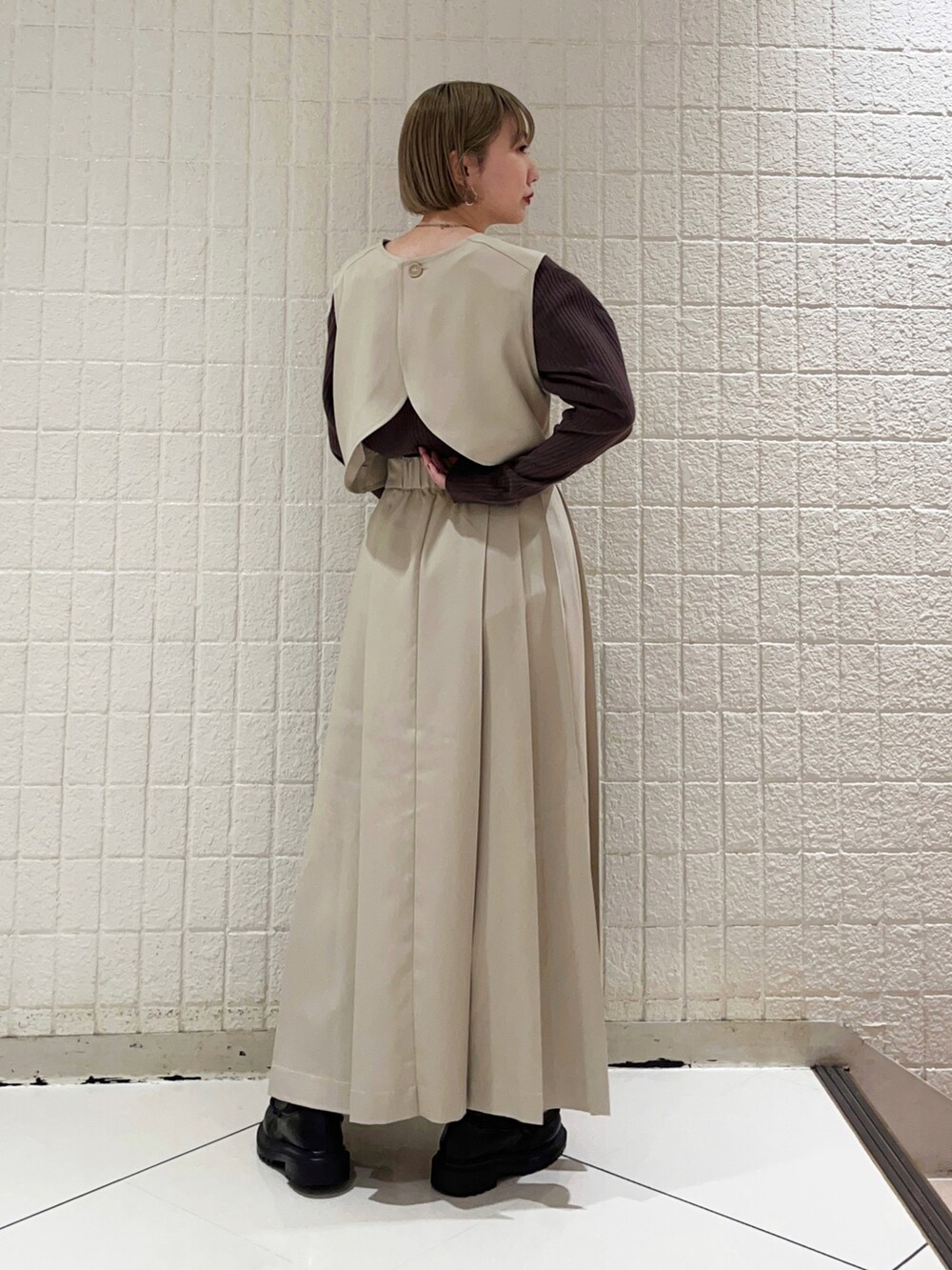 ベージュ系のワンピース、ブラック系のハンドバッグ、ブラウン系のTシャツ/カットソーを着用したレディースの秋コーディネートの3枚目の写真