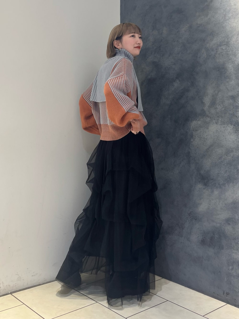 グレー系のニット/セーター、ブラック系のスカートを着用したレディースの冬コーディネートの3枚目の写真