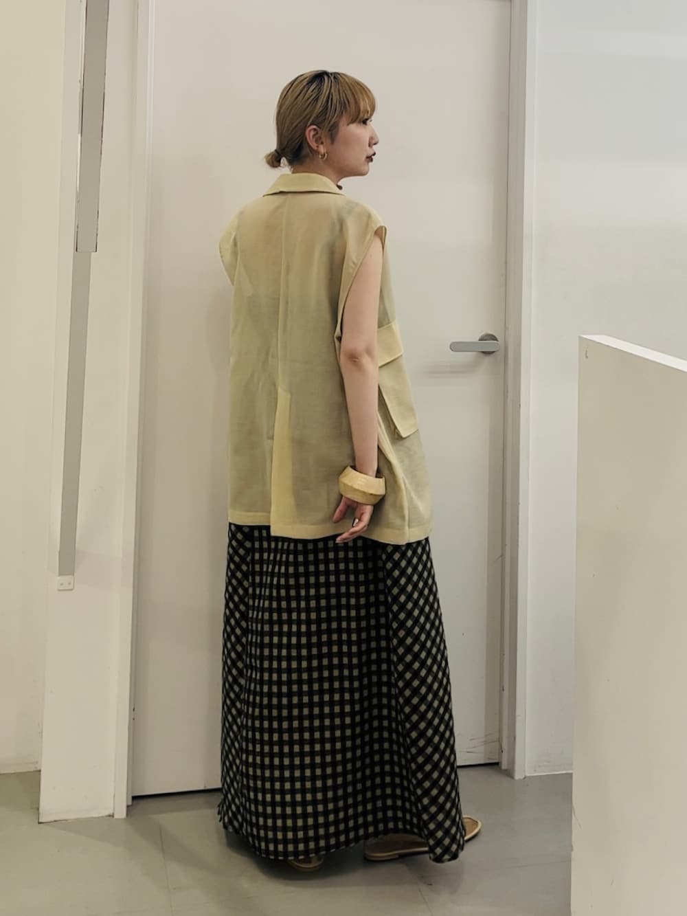 ベージュ系のベスト、グリーン系のワンピース、ベージュ系のその他シューズを着用したレディースの春コーディネートの3枚目の写真