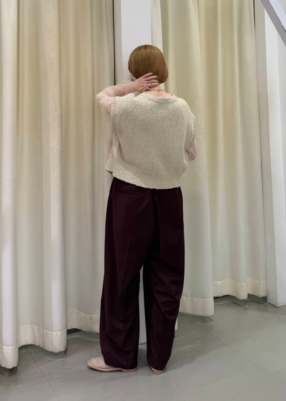 レッド系のその他パンツ、ベージュ系のニット/セーター、ホワイト系のTシャツ/カットソーを着用したレディースの春コーディネートの2枚目の写真