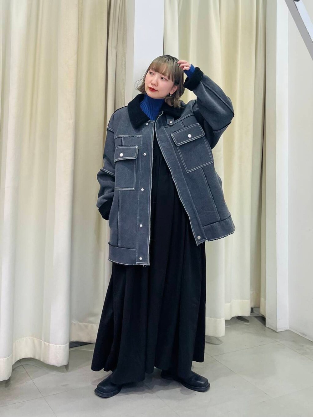 ブルー系のニット/セーター、ブラック系のその他アウター、ブラック系のワンピースを着用したレディースの秋コーディネートの2枚目の写真