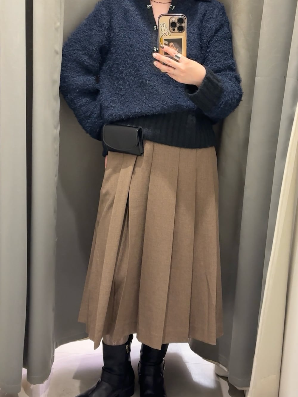 ブルー系のニット/セーター、ブラウン系のスカート、ブラック系のベルトを着用したレディースの冬コーディネートの2枚目の写真