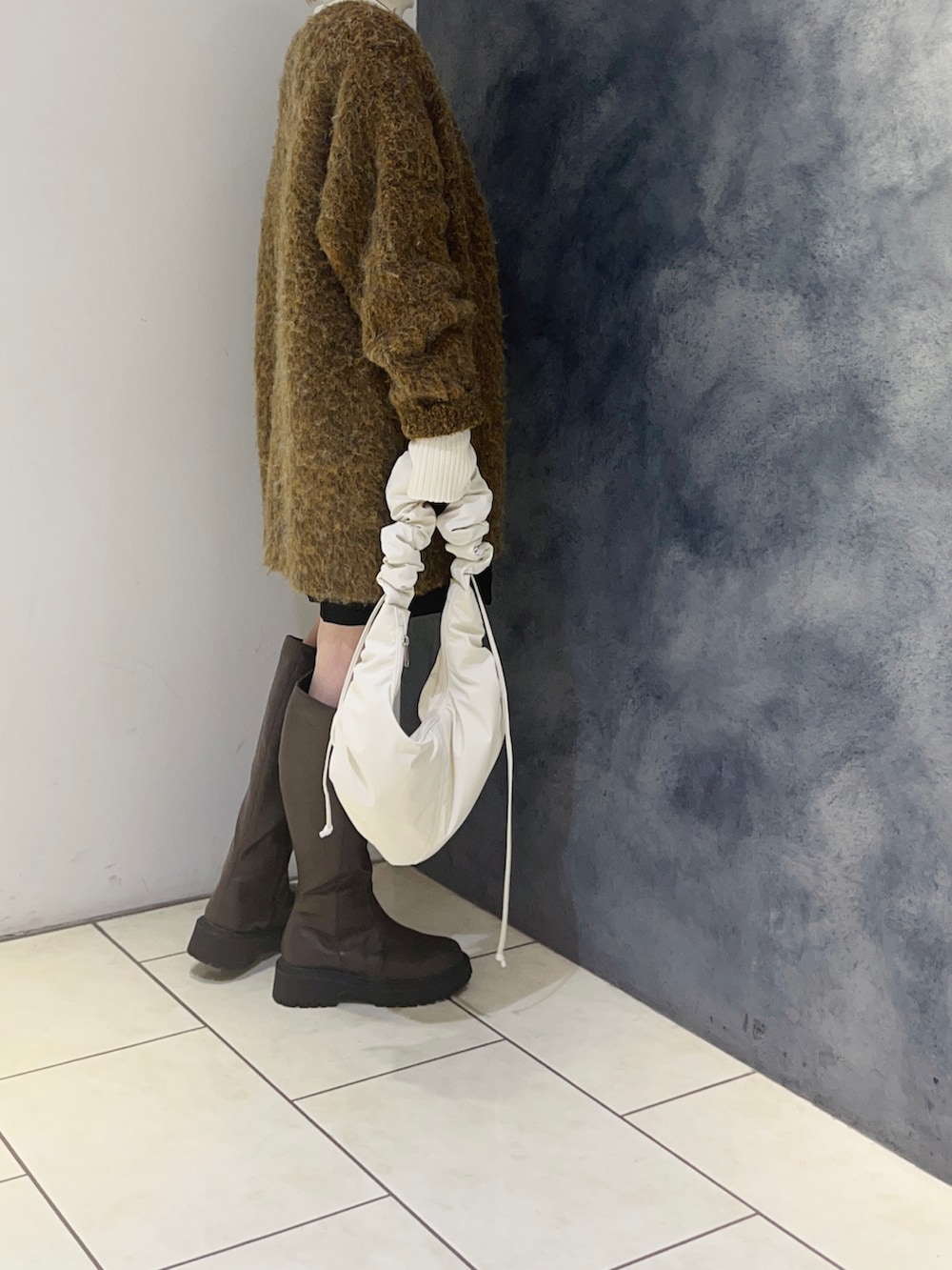 イエロー系のカーディガン/ボレロ、ホワイト系のニット/セーター、ブラック系のその他パンツを着用したレディースの冬コーディネートの4枚目の写真