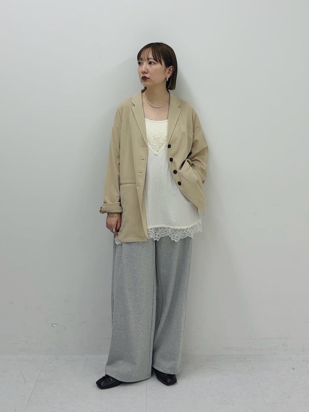 ベージュ系のその他アウター、ホワイト系のキャミソール、グレー系のその他パンツを着用したレディースの春コーディネートの2枚目の写真