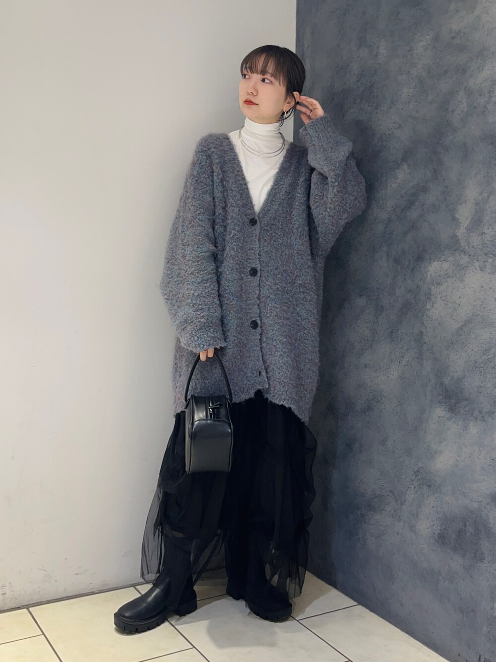 ブルー系のカーディガン/ボレロ、ブラック系のスカート、ホワイト系のTシャツ/カットソーを着用したレディースの秋コーディネートの2枚目の写真