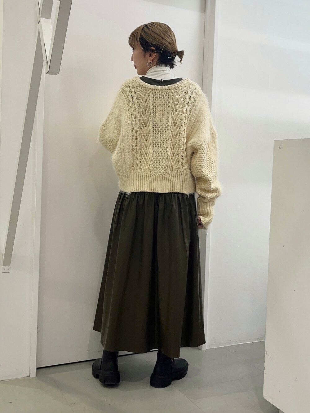 ホワイト系のニット/セーター、ブラウン系のワンピース、ブラック系のブーツを着用したレディースの冬コーディネートの3枚目の写真