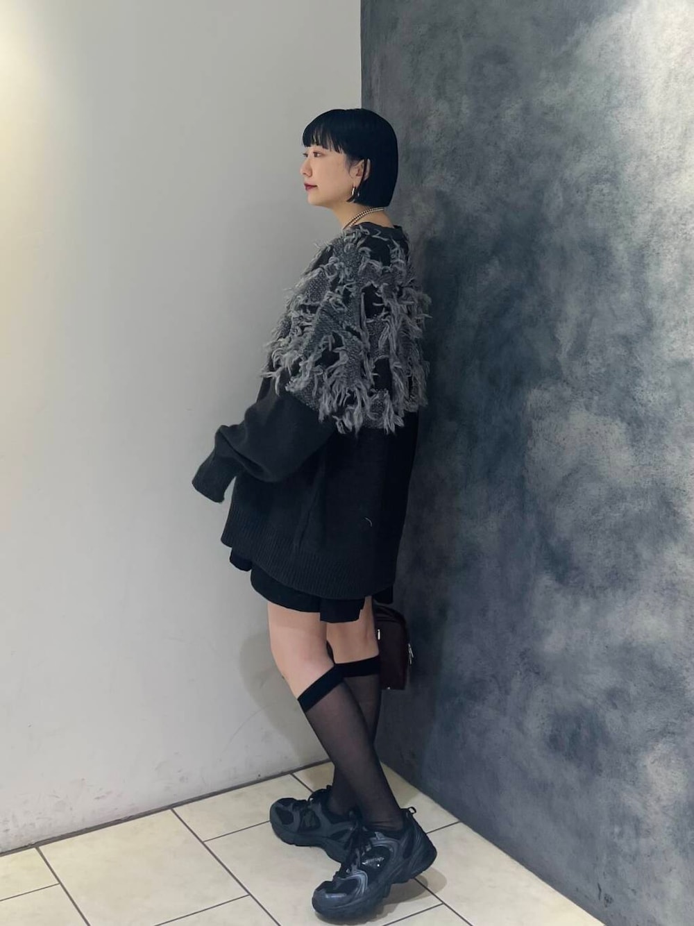 レッド系のボストンバッグ、ブラック系のワンピース、グレー系のTシャツ/カットソーを着用したレディースの秋コーディネートの3枚目の写真