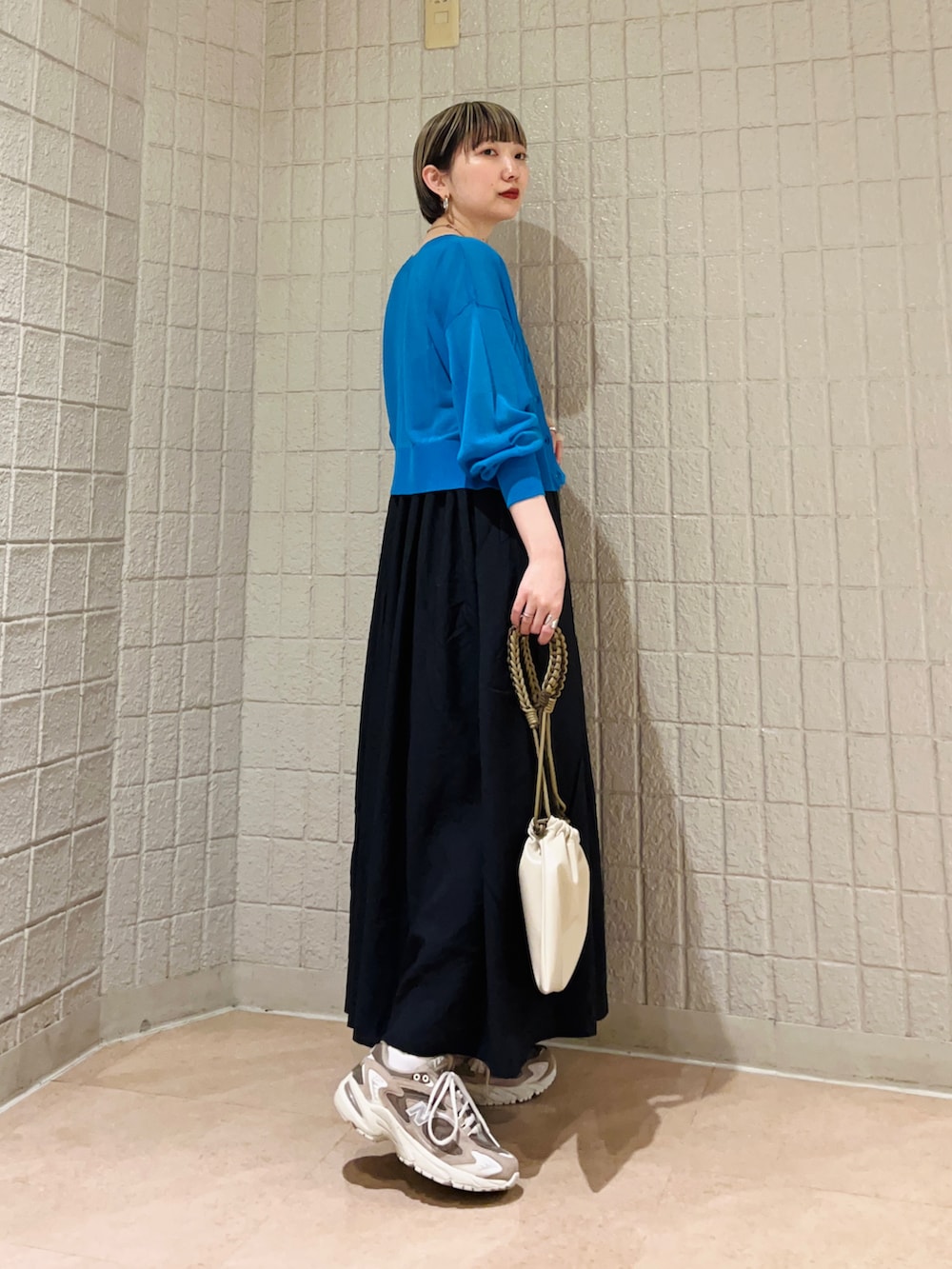 ブルー系のカーディガン/ボレロ、ブラック系のワンピース、ベージュ系のショルダーバッグを着用したレディースの春コーディネートの3枚目の写真