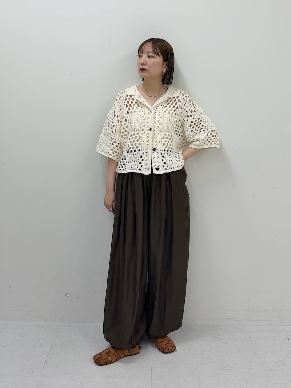 ホワイト系のニット/セーター、ブラウン系のその他パンツ、ブラウン系のサンダルを着用したレディースの春コーディネートの2枚目の写真