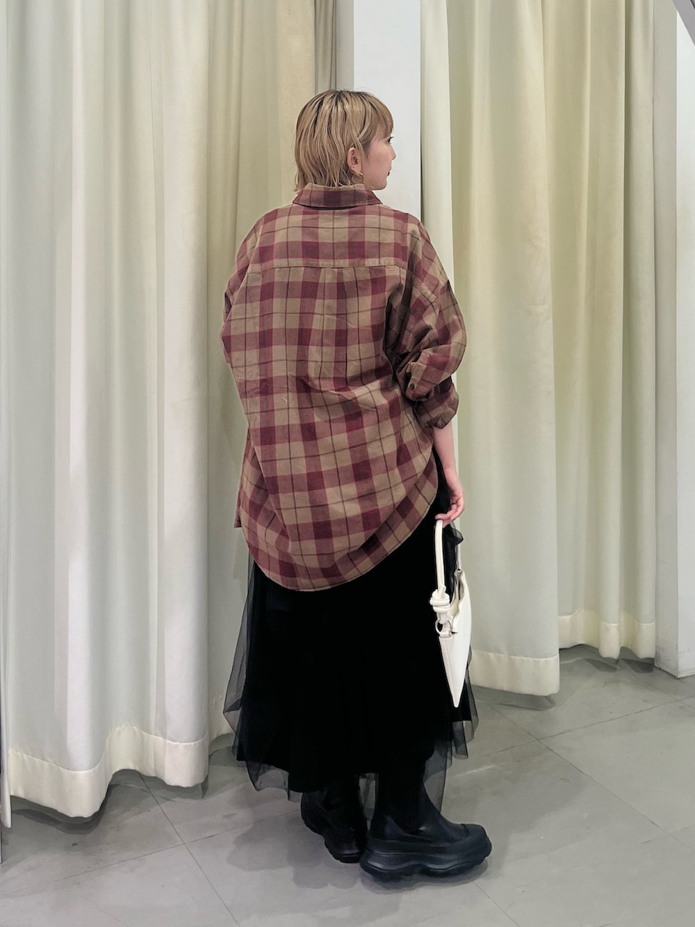 ブラウン系のシャツ/ブラウス、ブラック系のスカート、ブラック系のブーツを着用したレディースの秋コーディネートの4枚目の写真