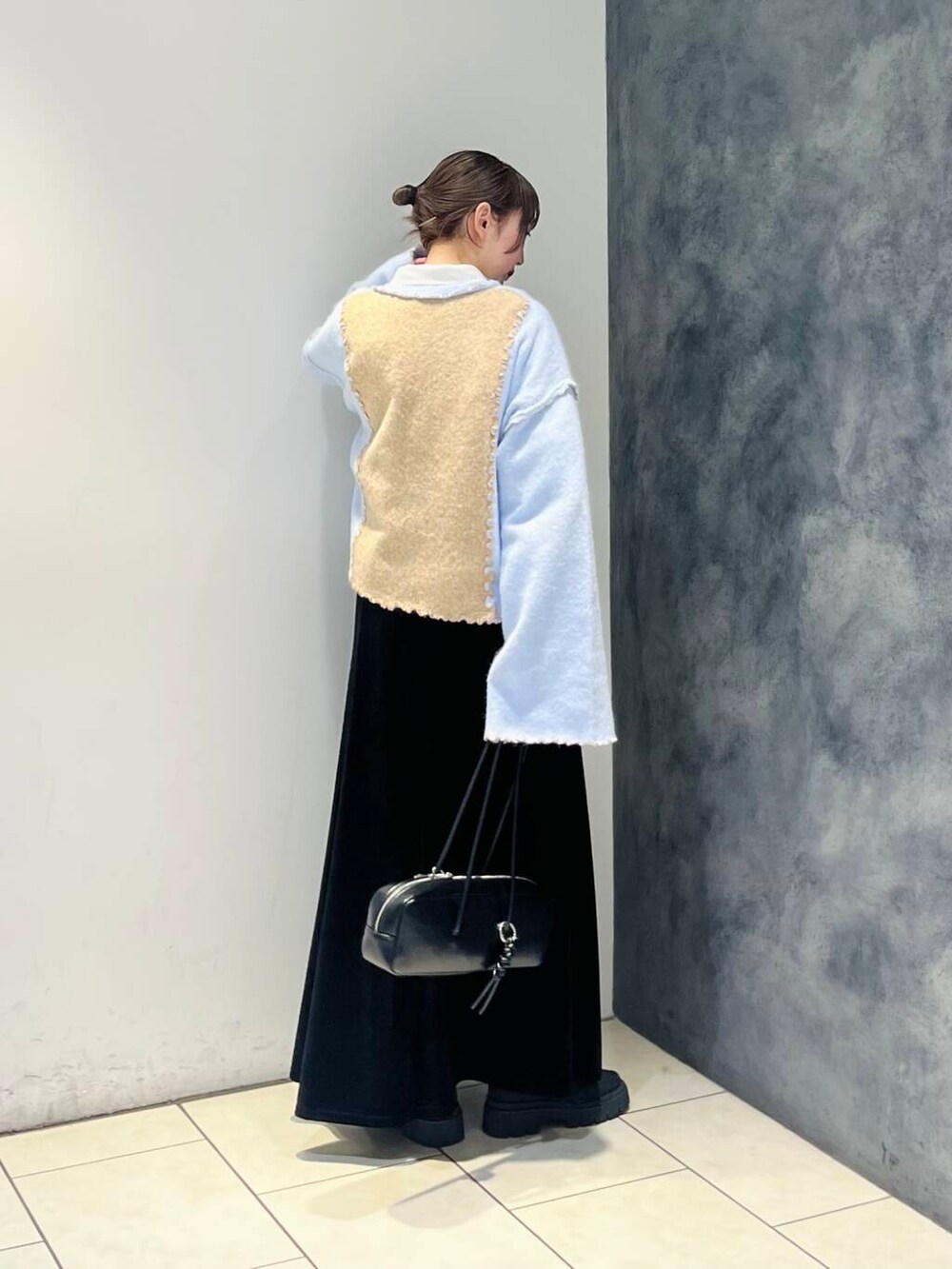 ブラック系のショルダーバッグ、ブラック系のスカート、ホワイト系のシャツ/ブラウスを着用したレディースの冬コーディネートの3枚目の写真
