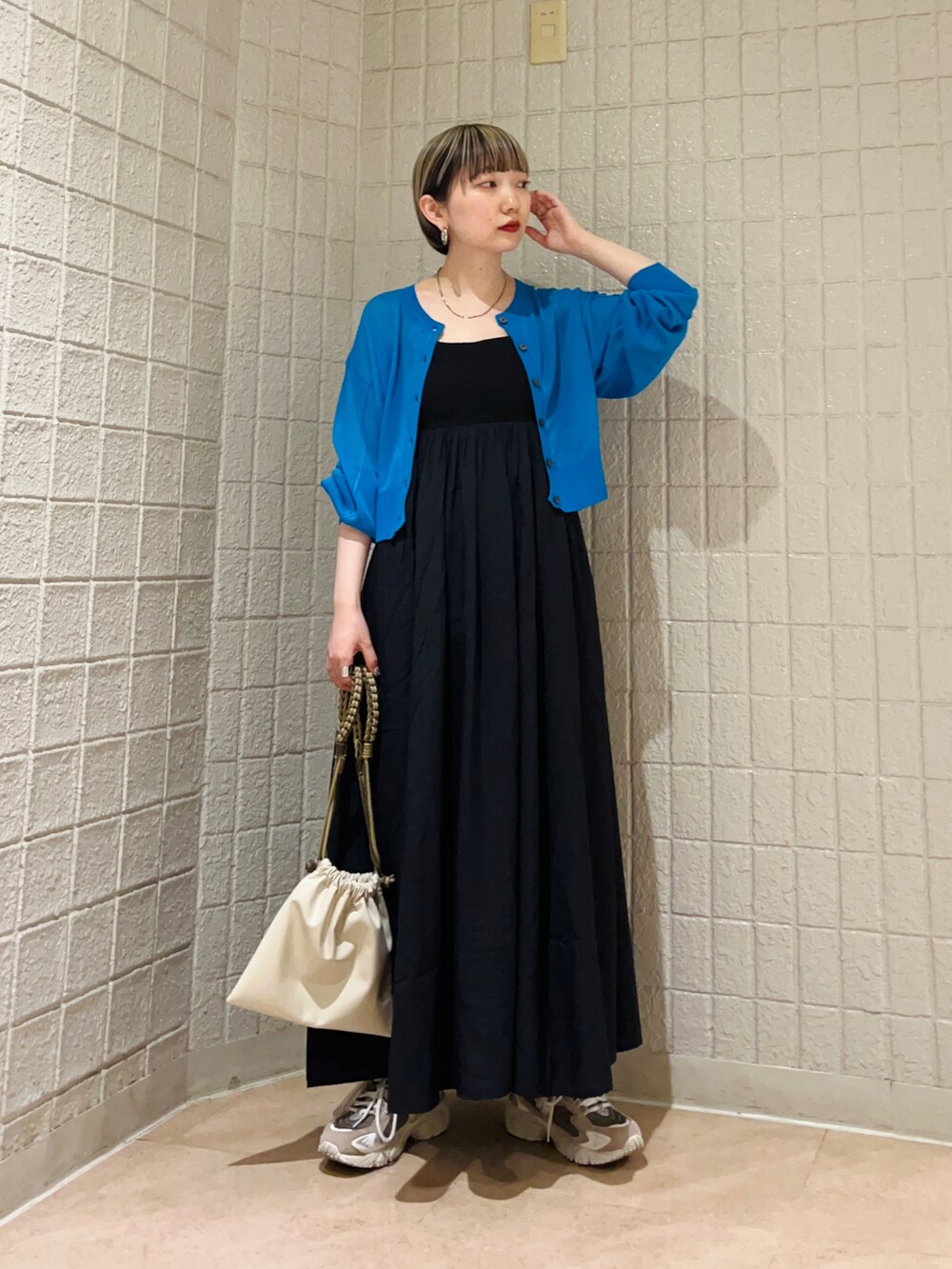 ブルー系のカーディガン/ボレロ、ブラック系のワンピース、ベージュ系のショルダーバッグを着用したレディースの春コーディネートの2枚目の写真