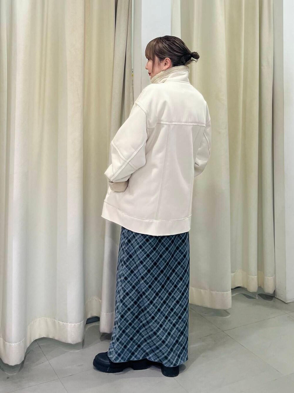 ホワイト系のその他アウター、グレー系のスカートを着用したレディースの冬コーディネートの3枚目の写真