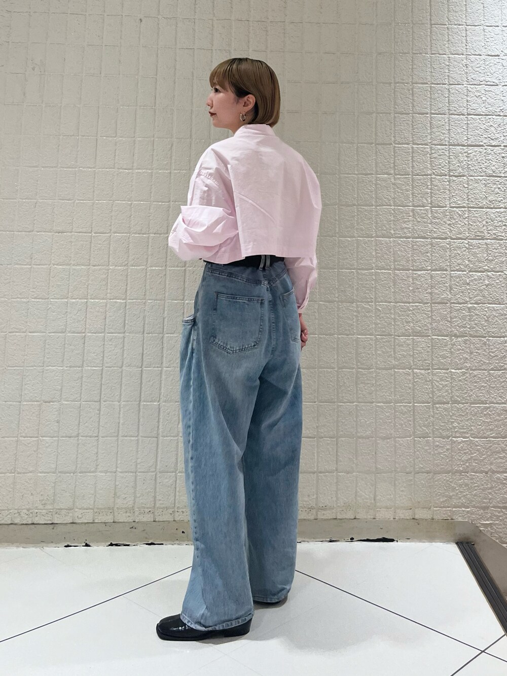 ブラック系のデニムパンツ、ピンク系のシャツ/ブラウス、ブラック系のその他シューズを着用したレディースの秋コーディネートの3枚目の写真