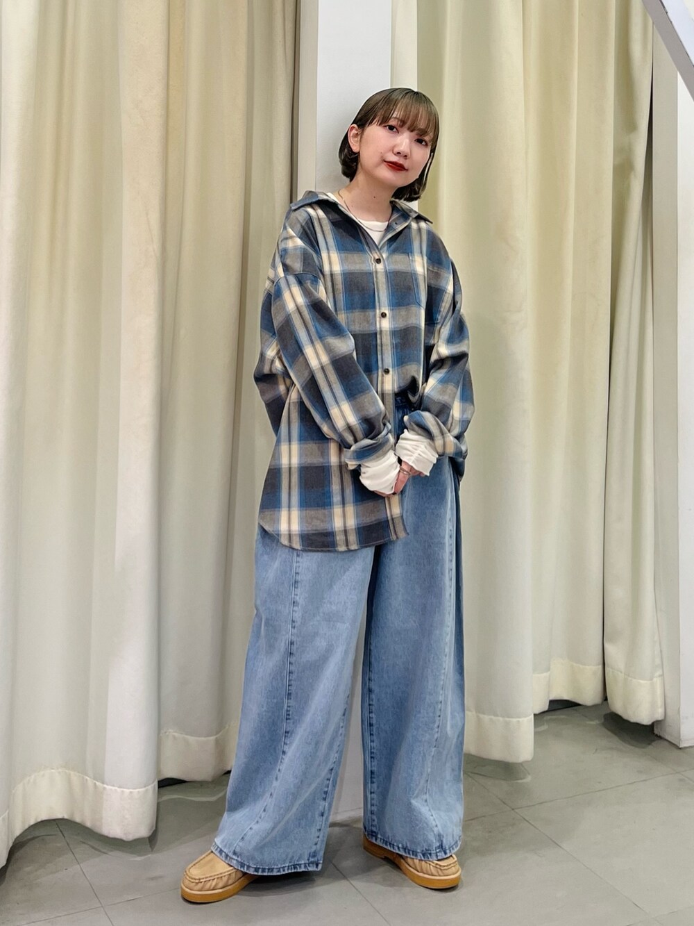 ベージュ系のシャツ/ブラウス、ブルー系のデニムパンツ、ホワイト系のTシャツ/カットソーを着用したレディースの秋コーディネートの4枚目の写真