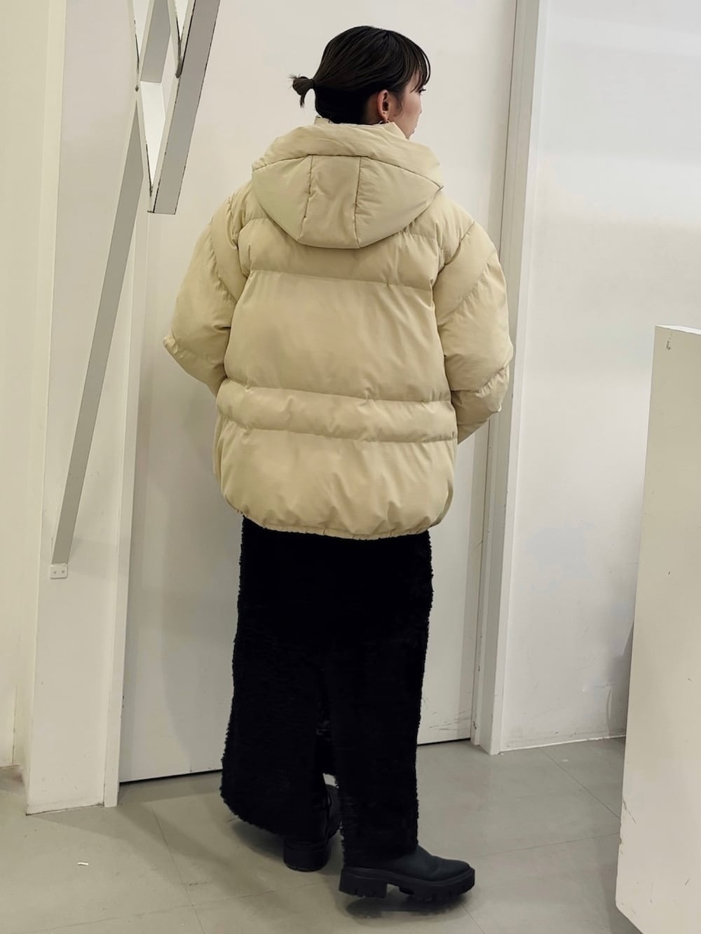 ベージュ系のダウンジャケット/コート、ブラック系のスカートを着用したレディースの秋コーディネートの4枚目の写真